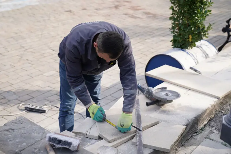 Metselaars met helmen bouwen een muur van bakstenen