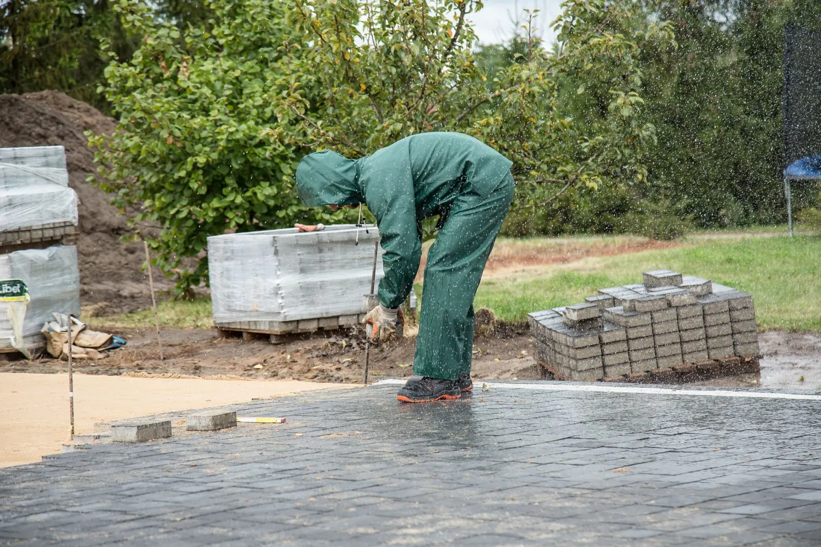 Stratenmaker legt betonklinkers op een nieuwe oprit